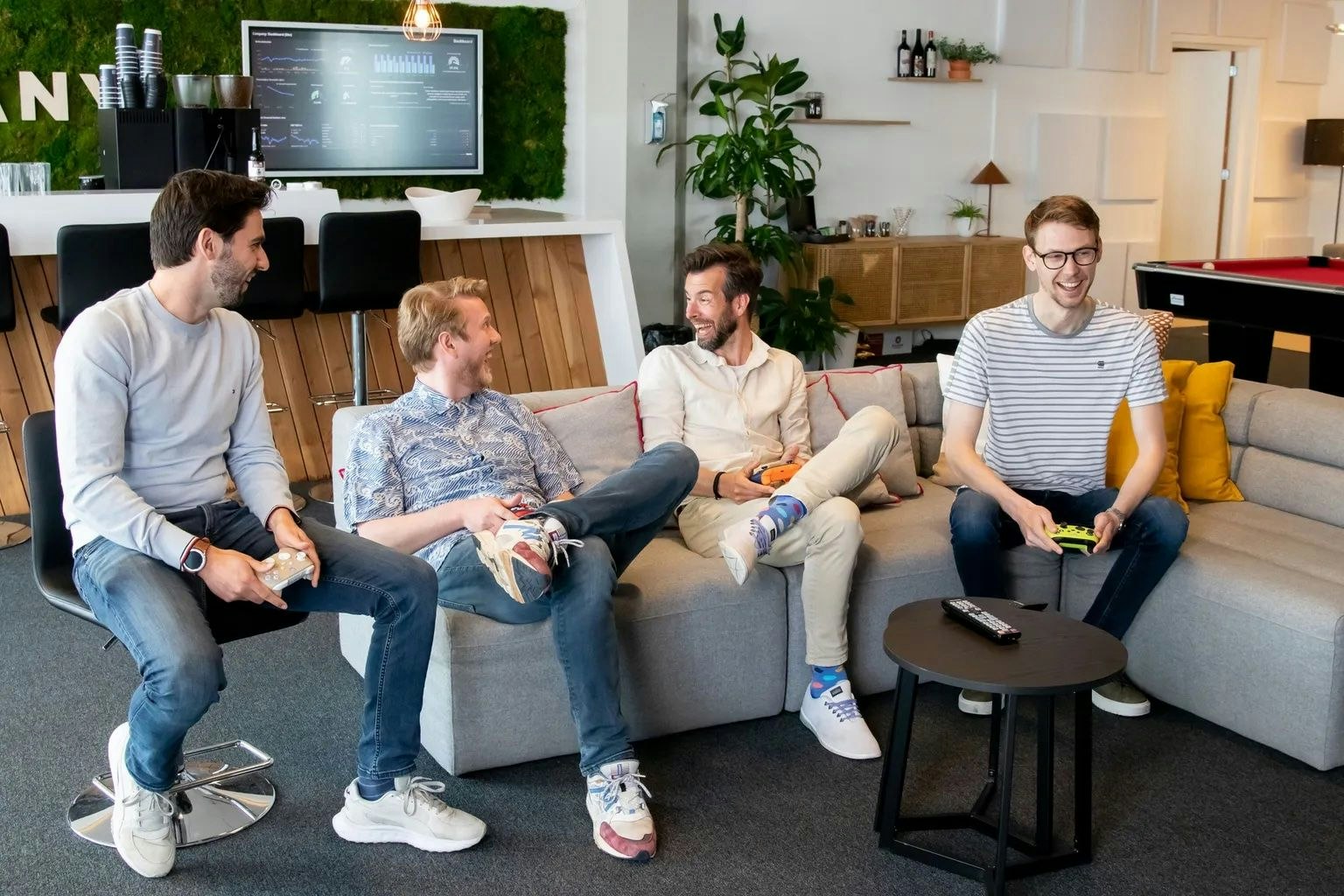 Vier mannen die naast elkaar zitten