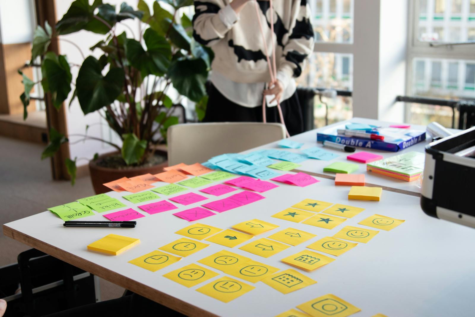 Een creatieve brainstormsessie met kleurrijke plakbriefjes en iconen op een whiteboard, wat het maken van de contentstrategie in digitale marketing laat zien.