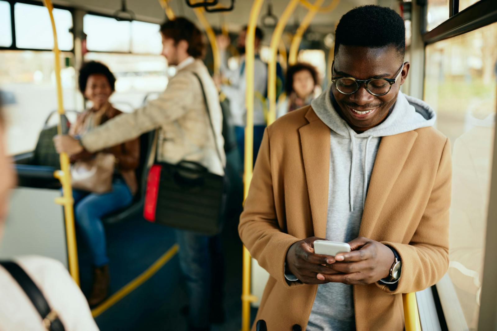 Man texting in the bus with a smile